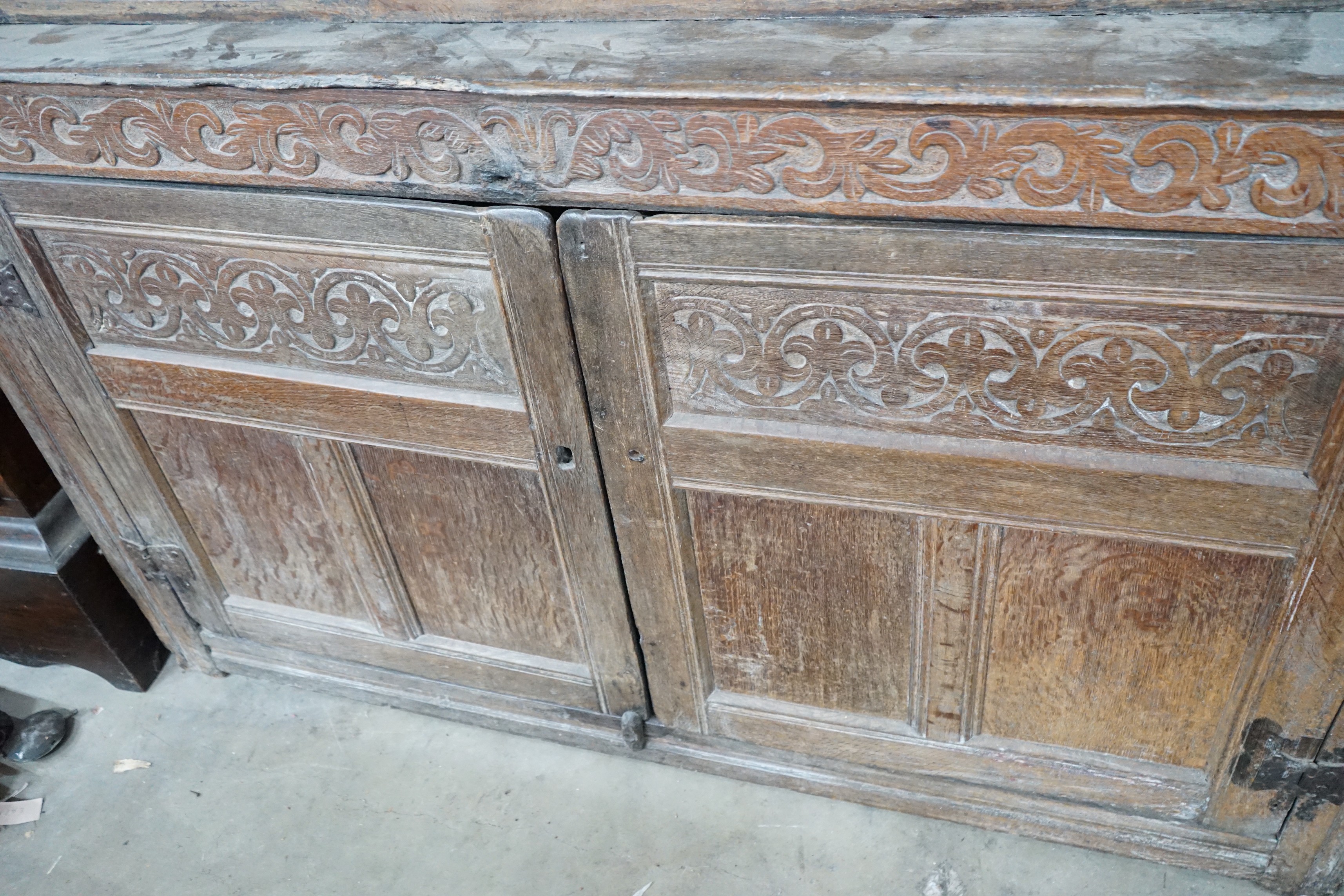 A 17th century carved oak court cupboard, dated 1685, width 170cm, depth 55cm, height 150cm